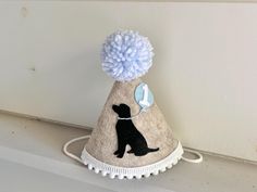 a hat with a pom - pom on it sitting on top of a shelf