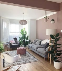 a living room filled with furniture and lots of plants