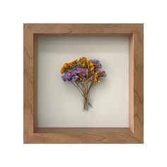 a wooden frame with dried flowers in it