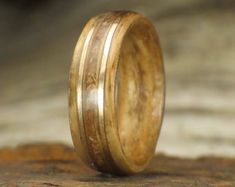 a wooden ring is sitting on top of a piece of wood with two lines in it