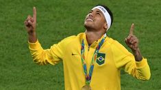 a man wearing a yellow shirt and headband holding up two fingers in the air