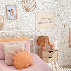 a bedroom with pink bedding and shells on the wall