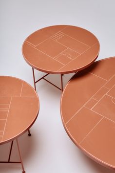 three tables that are made out of clay and have different designs on them, each one is shaped like a basketball court