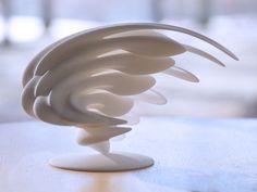 a white sculpture sitting on top of a wooden table