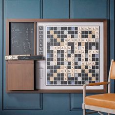 a framed scrabble board and chair in front of a chalkboard with writing on it