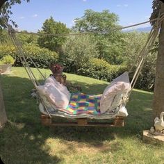 a hammock is set up in the grass with pillows and blankets on it