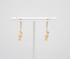 🎉Tiny enamel candy dangle earrings. 🎉Design and handcraft in our Burlington Studio ------------------------------------------------------------- PRODUCTS DETAILS Length: 29mm Width: 5mm Lever back: 14K gold filled Candy drop: 14K gold plated enamel ------------------------------------------------------------- SAME COLLECTION Necklace https://www.etsy.com/ca/listing/771460195/tiny-enamel-candy-necklace-14k-gold?click_key=b044d590c58e79aa95964c877bc70f9e68f174fc%3A771460195&click_sum=5f3b091c&ref=shop_home_active_28&sts=1 ------------------------------------------------------------- MATERIALS INTRODUCTION:  GOLD FILLED FINDINGS Gold filled is an actual layer of 5% pure gold by weight pressure bonded to another metal. Gold filled is not to be confused with gold plating as filled literally h Yellow Gold Earrings With Dangling Charms For Gift, White Enamel Jewelry For Party, Yellow Gold Earrings With Dangling Charms As Gift, Yellow Gold Enamel Dangle Earrings, Yellow Gold Charm Earrings For Gift, Sweet Nickel-free Dangle Jewelry, Yellow Gold Enamel Earrings As Gift, Sweet Drop Earrings Jewelry Gift, White Earrings With Dangling Charms For Gift