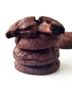 three chocolate cookies stacked on top of each other with one bite taken out of it