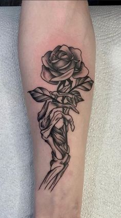 a black and white rose tattoo on the leg