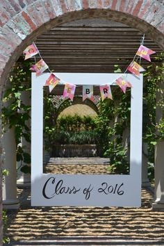 a sign that says class of 2016 hanging from the side of a brick arch in front of an archway