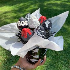 a hand holding a vase filled with chocolate covered candies