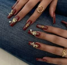 Classy Red And Gold Nails, Gold Red Nails Acrylic, Cute Red And Gold Nails, Red N Gold Nails, Dark Red Acrylics, Red Nails With Charms, Nail Art Red And Gold, Dark Red And Gold Nails, Extravagant Nails Designs