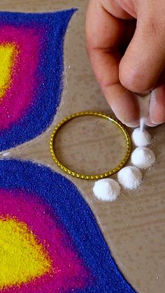 someone is making an art project with yarn and cotton balls