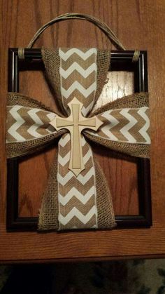 a cross made out of burlock on top of a wooden frame hanging from a wall