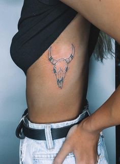 a woman with a bull's head tattoo on her stomach