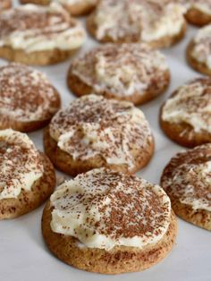 several cookies with white frosting and cinnamon sprinkles on top are shown