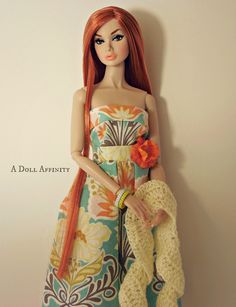 a doll with long red hair is wearing a dress