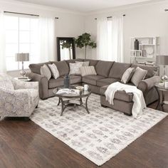 a living room filled with furniture and a white rug on top of a hard wood floor