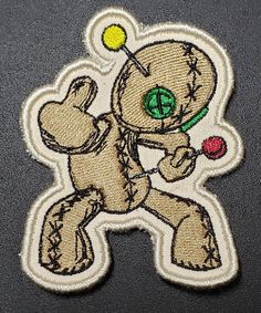 a teddy bear with a tennis racket and ball in it's hand embroidered patch