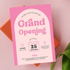 a pink and orange birthday card with the words grand opening on it next to a plant