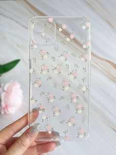 a hand holding a clear case with flowers on it