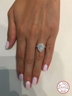 a woman's hand with pink manicured nails and a ring on her finger