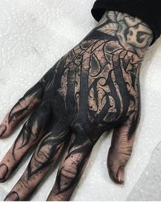 a person's hand covered in black ink with an intricate design on the palm