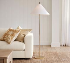 a living room with a couch, lamp and coffee table