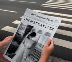 a person holding up a newspaper in front of a crosswalk with the words the best day ever