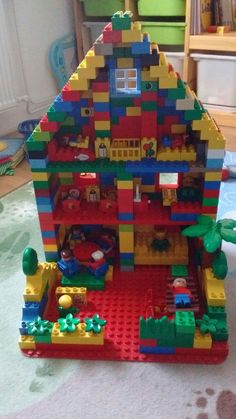 a toy house made out of legos on the floor in a child's room