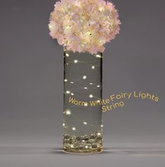 a glass vase with flowers in it that says worth white forty lights string on the bottom