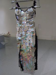 a dress made out of books hanging on a clothes line in an art gallery with white floors