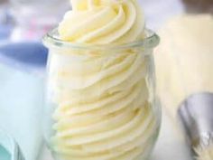 a glass jar filled with whipped cream on top of a table