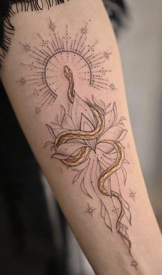 a woman's arm with a snake and sun tattoo on the left side of her arm