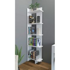 a book shelf with several books on it and a plant in the corner next to it