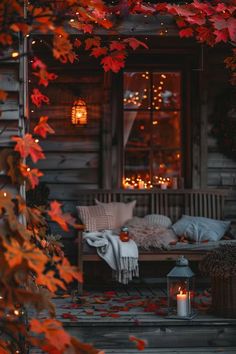 a porch covered in fall leaves and lit up with candles for the night time atmosphere