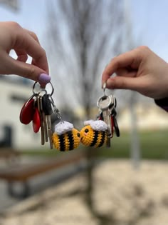 two people holding keys to each other in the shape of bees with eyes and noses