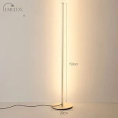 the floor lamp has a dim light on it and is next to a white wall