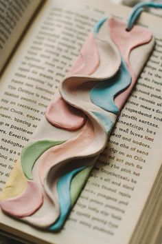 a bookmark made out of clay sitting on top of an open book