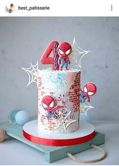 a spiderman birthday cake with the number four on it's top and decorations