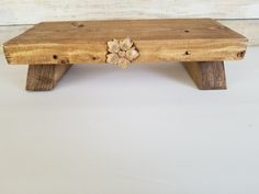 a wooden bench made out of wood with flowers on the top and bottom, sitting against a white background