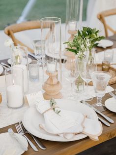 the table is set with white plates and silverware