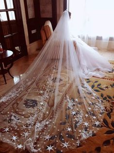 a woman in a wedding dress is sitting on the floor with her veil over her head