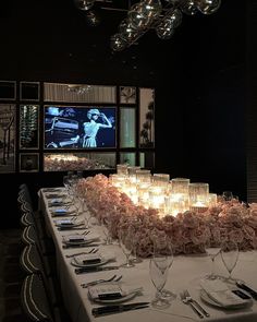 a long table is set up with candles and place settings for the dinner guests to enjoy