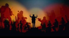 the silhouette of a man standing on top of a stage with his arms in the air