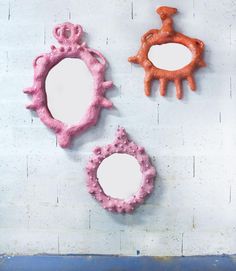 three different shaped mirrors sitting on top of a wall