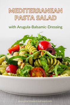 a white bowl filled with pasta salad on top of a table