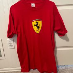 Never Worn Ferrari T-Shirt In The Iconic Ferrari Red Color Retro Red Top With Letter Print, University Red Crew Neck Fan Apparel Top, Red Retro Top With Graphic Print, Retro Red T-shirt With Logo Print, University Red Crew Neck Tops For Fans, Red Long Sleeve T-shirt With Logo Print, University Red Logo Print Crew Neck Top, Retro Short Sleeve Fan Merchandise Shirt, University Red Crew Neck Graphic Tee