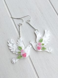 Delicate bridal earrings made with silver plated findings, acrylic doves and, roses and leaves. The earrings are approximately 6 cm long Delicate Bridal Earrings, Peace Dove, Bridal Earrings, Pink Rose, Favorite Jewelry, Jewelry Earrings Dangle, Dangle Drop Earrings, Accessory Gift, Drop Earrings