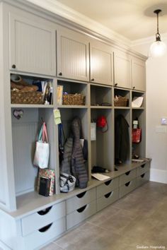 a large walk in closet with lots of drawers and bins on the wall next to it